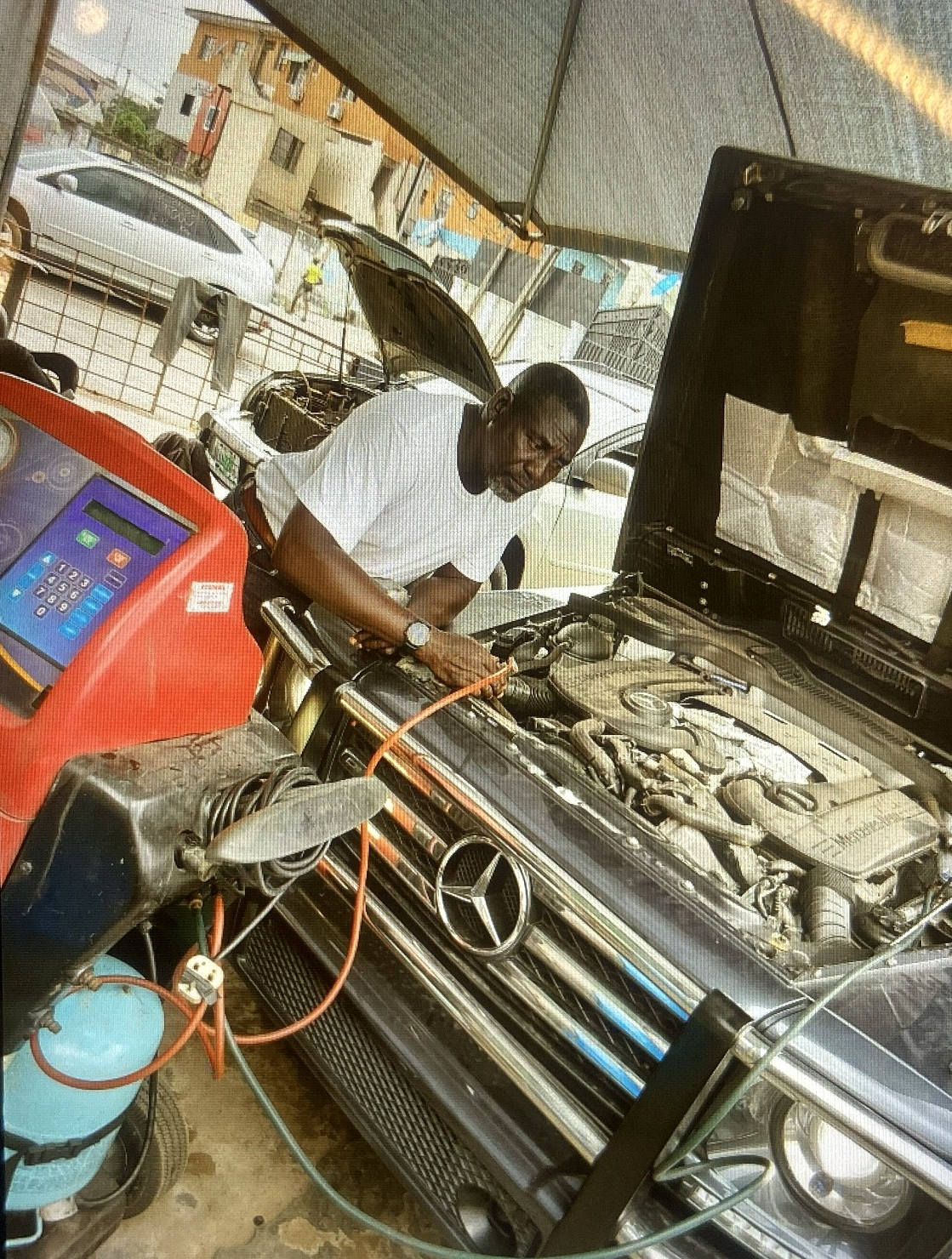 Technician repairing a car AC system